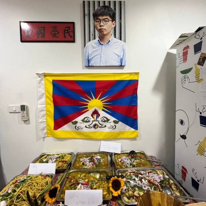 A portrait of Joshua Wong (one of Hong Kong’s pro-democracy protest leaders), a Tibetan flag, and Rohingya food.