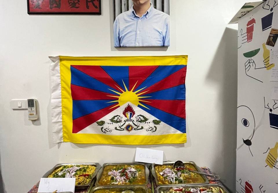 A portrait of Joshua Wong (one of Hong Kong’s pro-democracy protest leaders), a Tibetan flag, and Rohingya food.