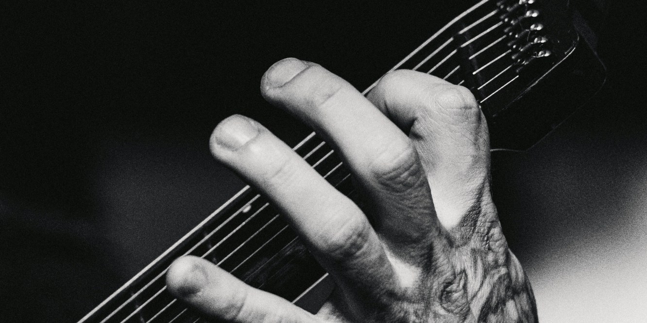 Hand on the fret of a guitar