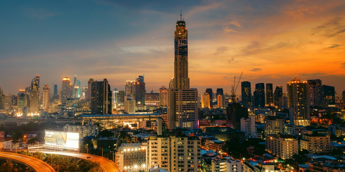Aerial view of Bangkok with the sun setting in the background.